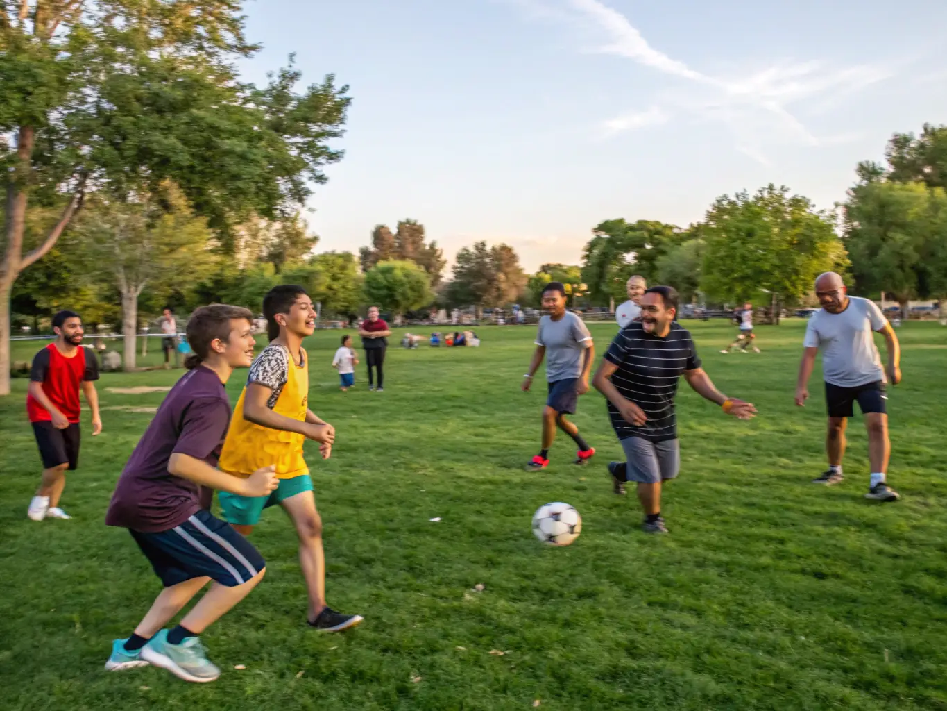 A group of diverse community members participating in a soccer game, showcasing teamwork and active engagement in 40 ANS ASCL's sports program.